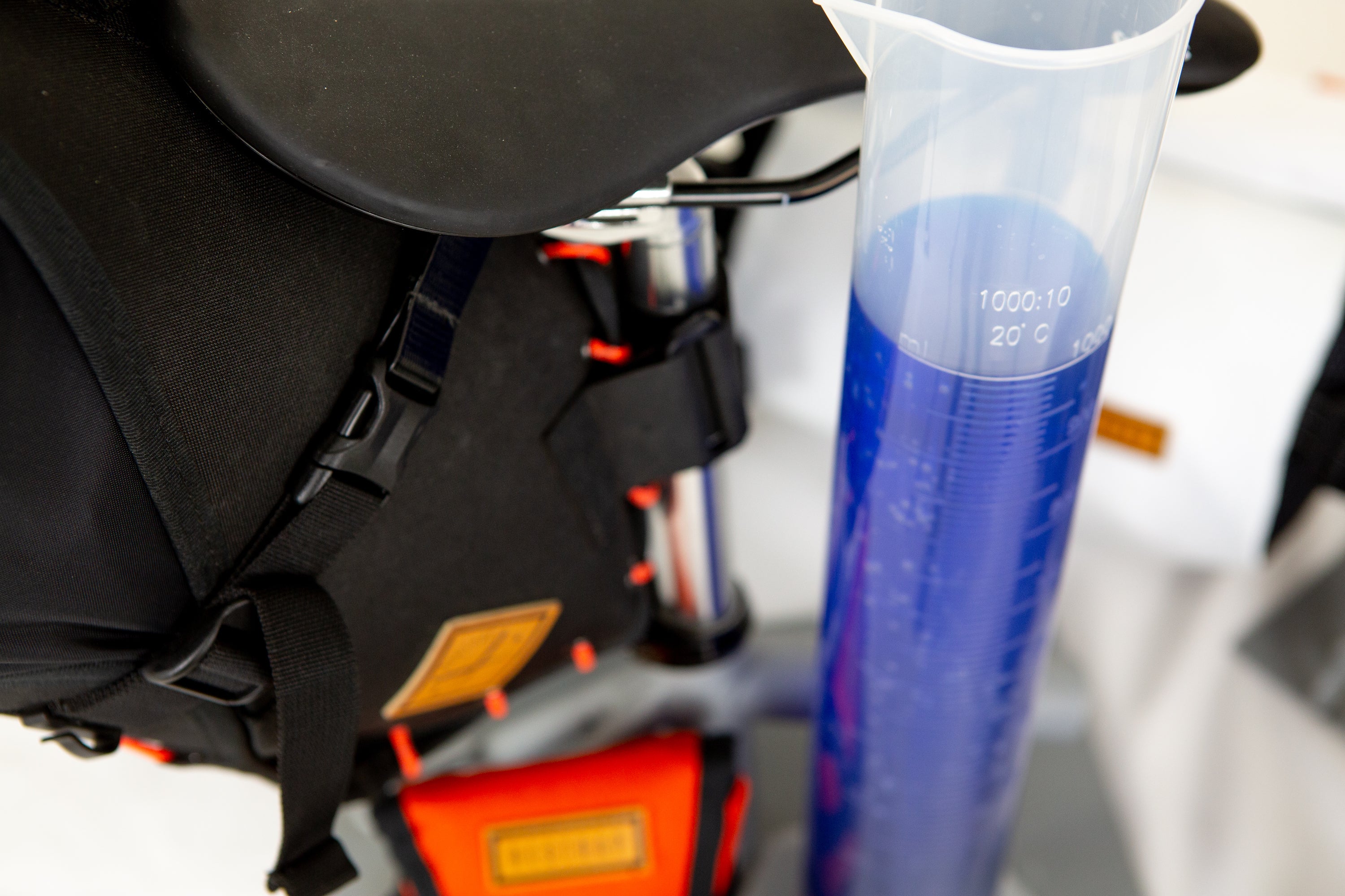 restrap saddle bag with a beaker with fluid to demonstrate capacity