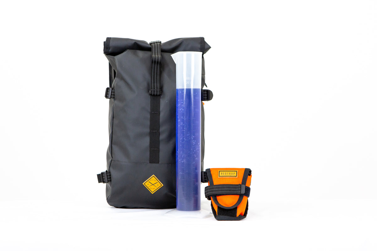 restrap backpack and tool pouch with a beaker of fluid to demonstrate capacity measuring