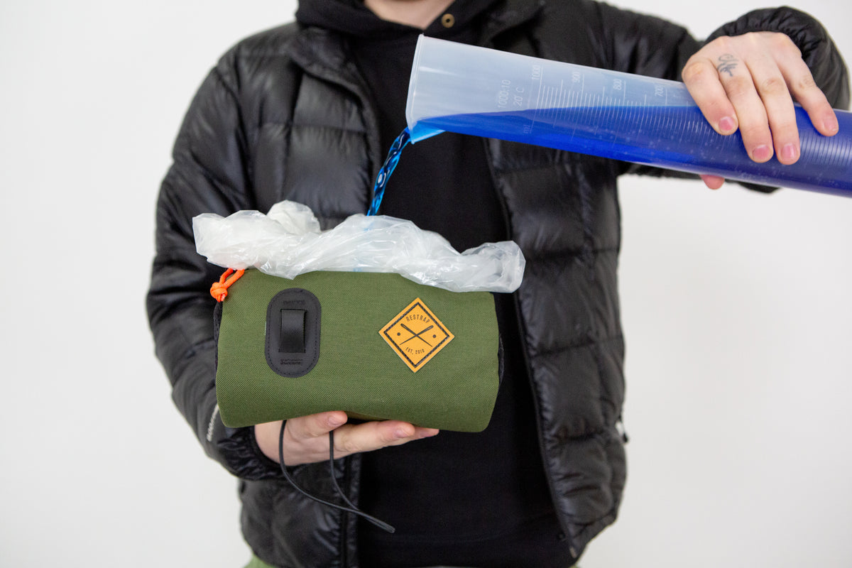 fluid being poured into a restrap bag to measure it's capacity accurately