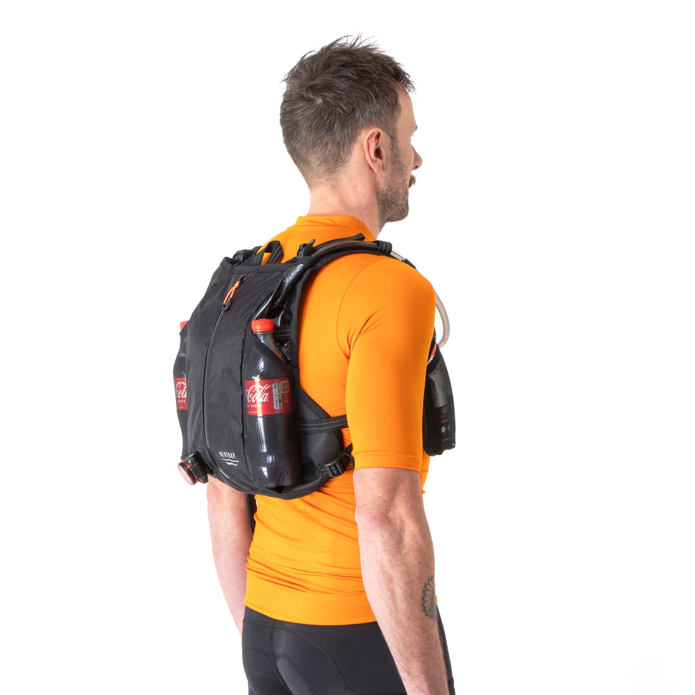 Rear of the Restrap race hydration vest on a man, showing the reflective label and zip compartment