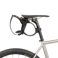 Black race saddle bag holster attached to a bike frame on a white background