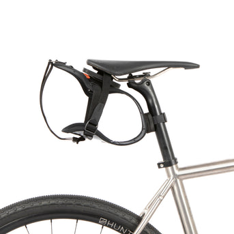 Black race saddle bag attached to a bike frame on a white background