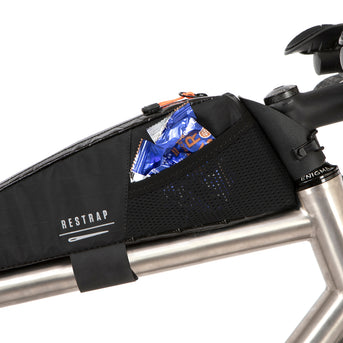 A black Race Top Tube Bag attached to the frame of a bicycle, designed to hold items while cycling.