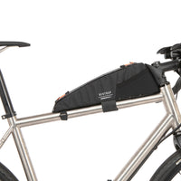 A black Race Top Tube Bag attached to the frame of a bicycle, designed to hold items while cycling.