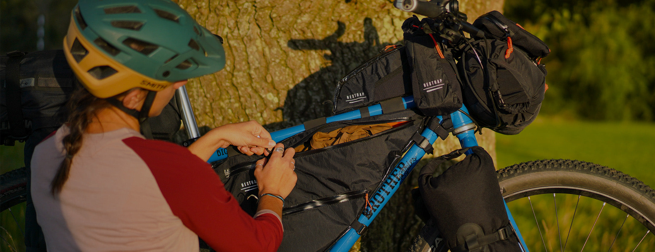 woman packing restrap frame bag with various gear
