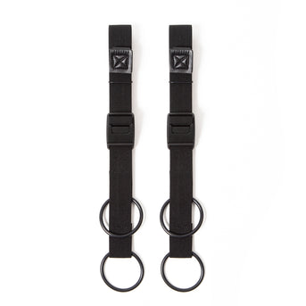 A pair of black Restrap luggage straps with rubber o-rings and magnetic buckles on a white background.