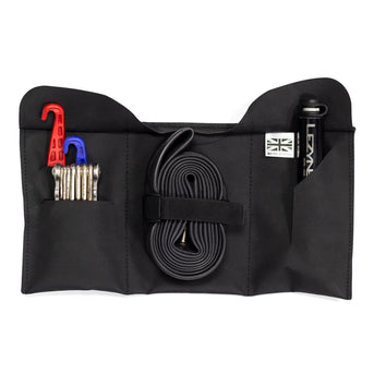 A black Restrap tool roll with a visible brand label, designed to be attached to a bicycle saddle or kept in a jersey pocket.
