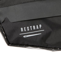 closeup of the label on A small black race frame bag attached to the frame of a bicycle, designed for bikepacking.