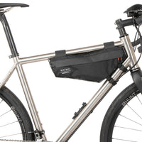 A small black race frame bag attached to the frame of a bicycle, designed for bikepacking.