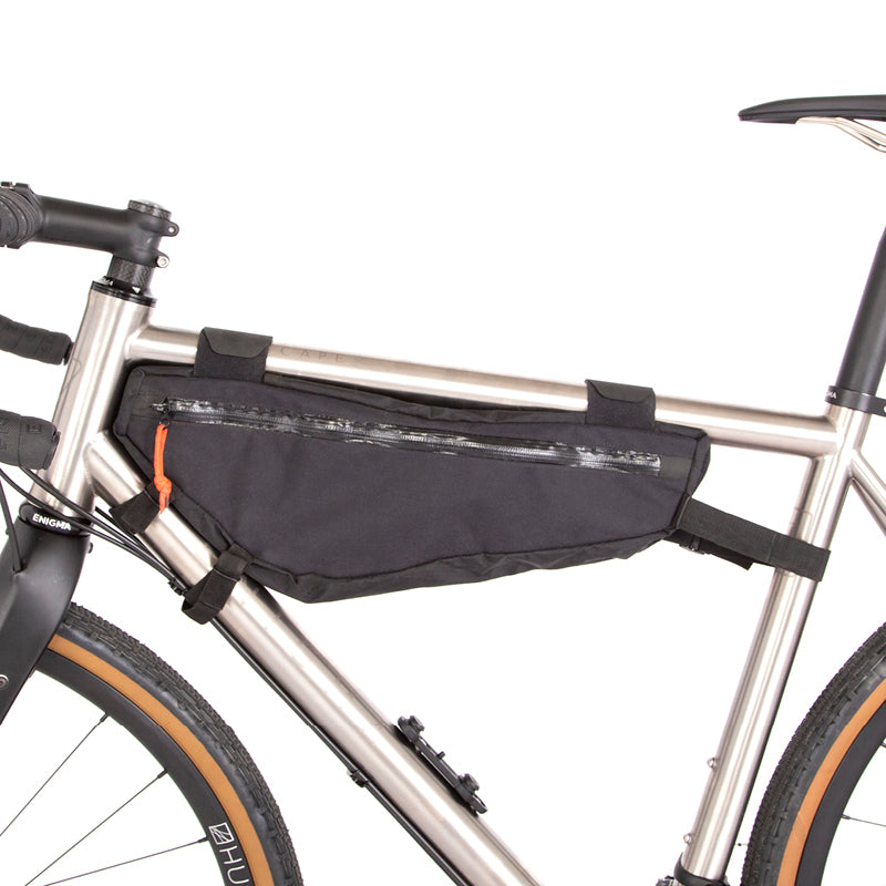 A black Restrap frame bag medium attached to the down tube of a bicycle, shown from the non drive side