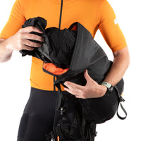 Person in orange cycling jersey and black backpack on a white background