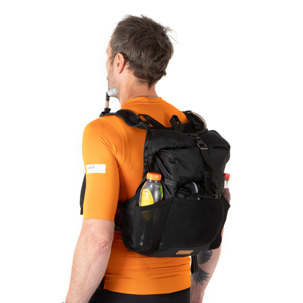 Person wearing a black backpack with a white background