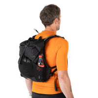 Man wearing a black backpack with a bottle on a white background
