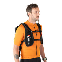 Man wearing an orange shirt and black backpack with a white background
