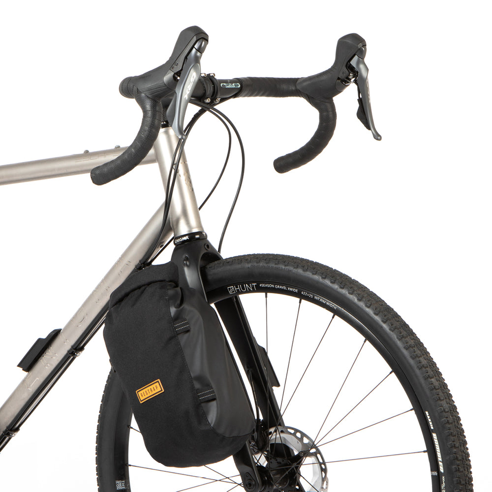 Restrap Switch Pannier attached to the fork of a bike on a white background