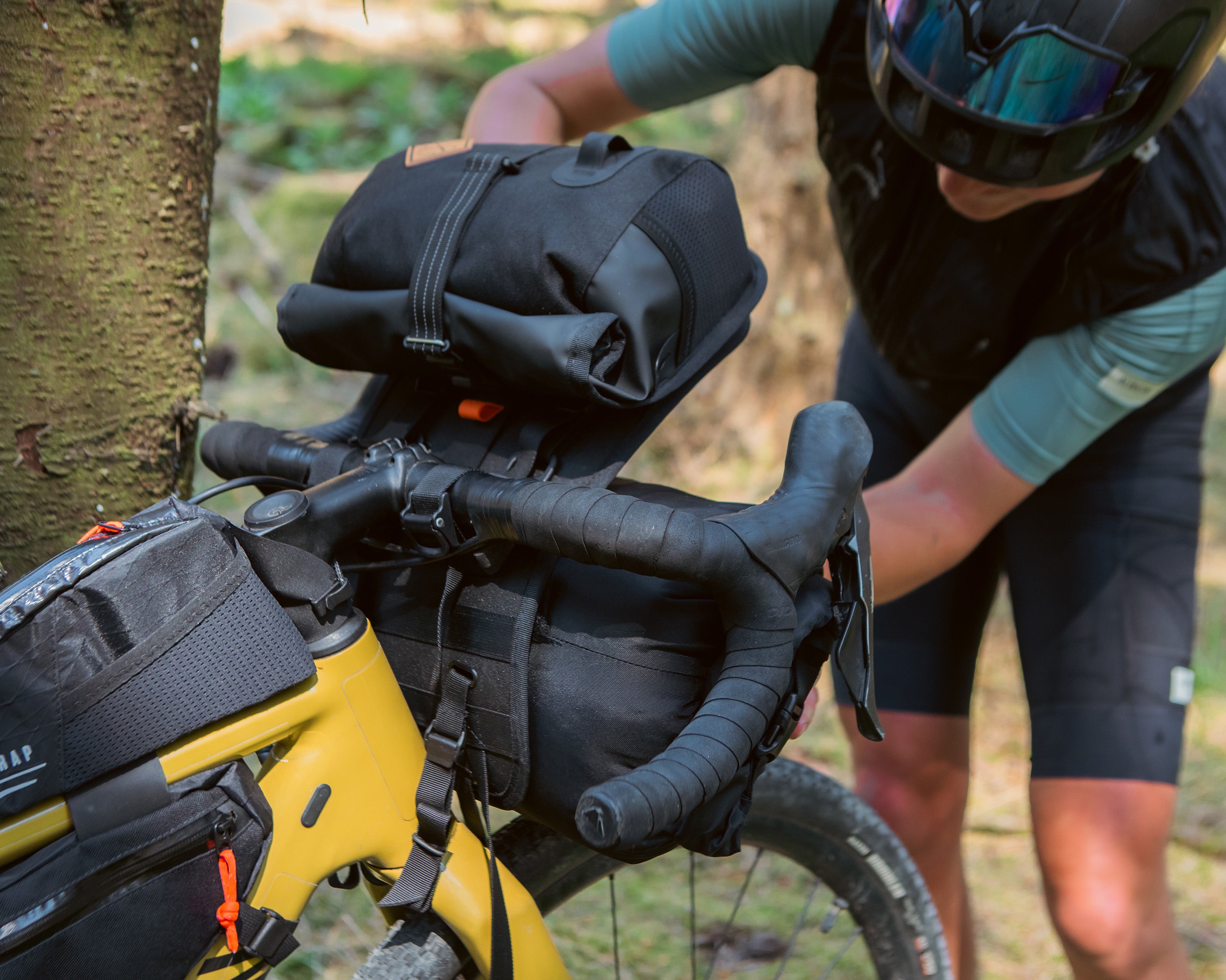 female rider using the holster system on a restrap bar bag