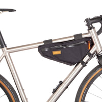 A black Restrap frame bag small attached to the down tube of a bicycle, featuring a visible zipper and the brand's label.