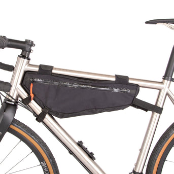 A black Restrap frame bag medium attached to the down tube of a bicycle, featuring a visible brand label and YKK zippers.
