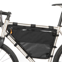 A large black full frame bag attached to a bicycle frame, with adjustable straps visible from the left side